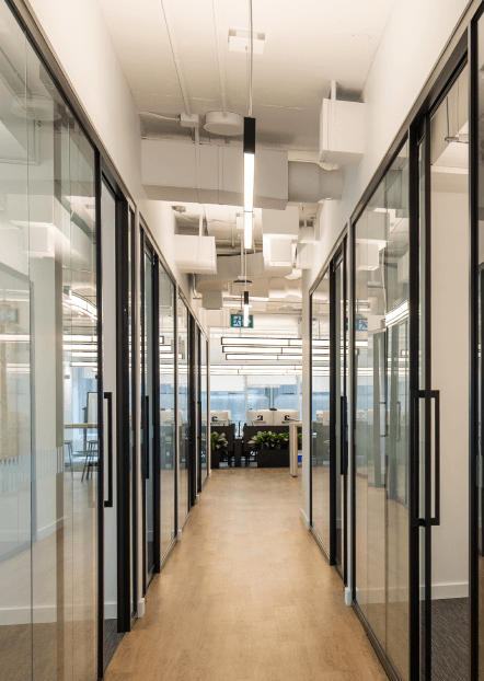 The corridor of the Oakbank Capital Group office in Toronto, lined with glass-walled meeting rooms